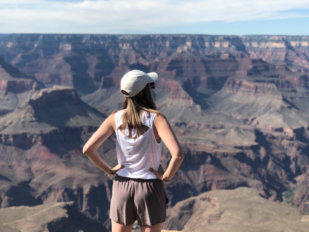 woman with hat looking at grand canyon